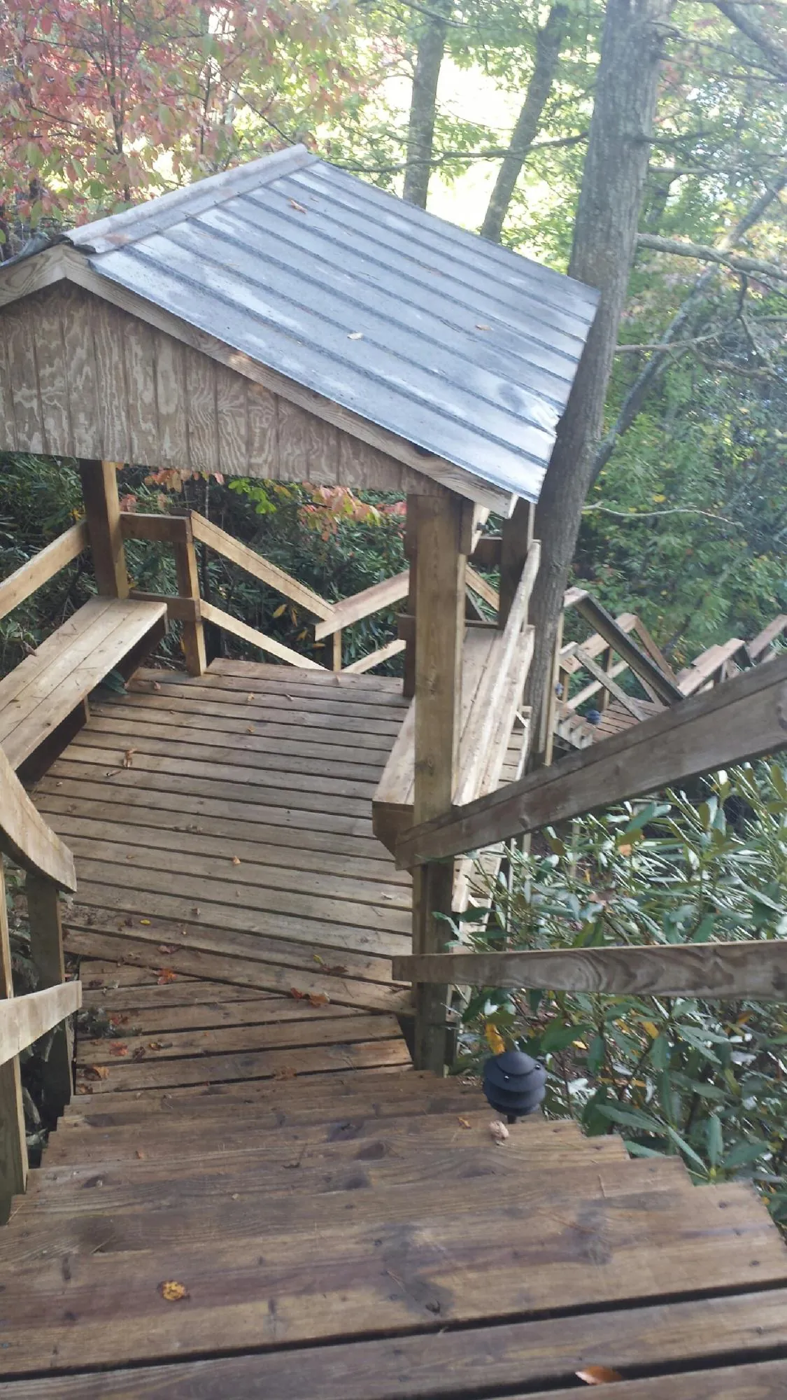 Metal roofed shelter over wooden steps on a wooded walkway — Skylight Repair & Installation work by our crew in Lithonia