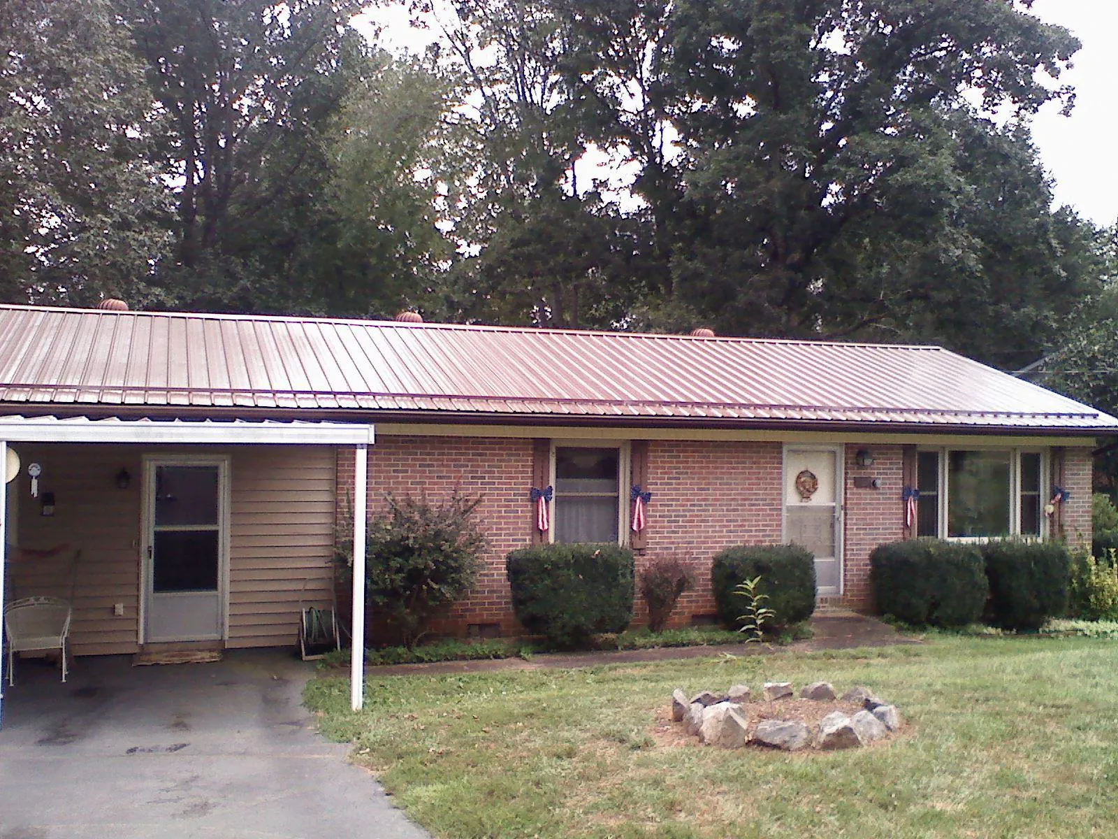 Bronze metal roof and carport on a brick ranch home — Roof Repair work by our crew in Lithonia