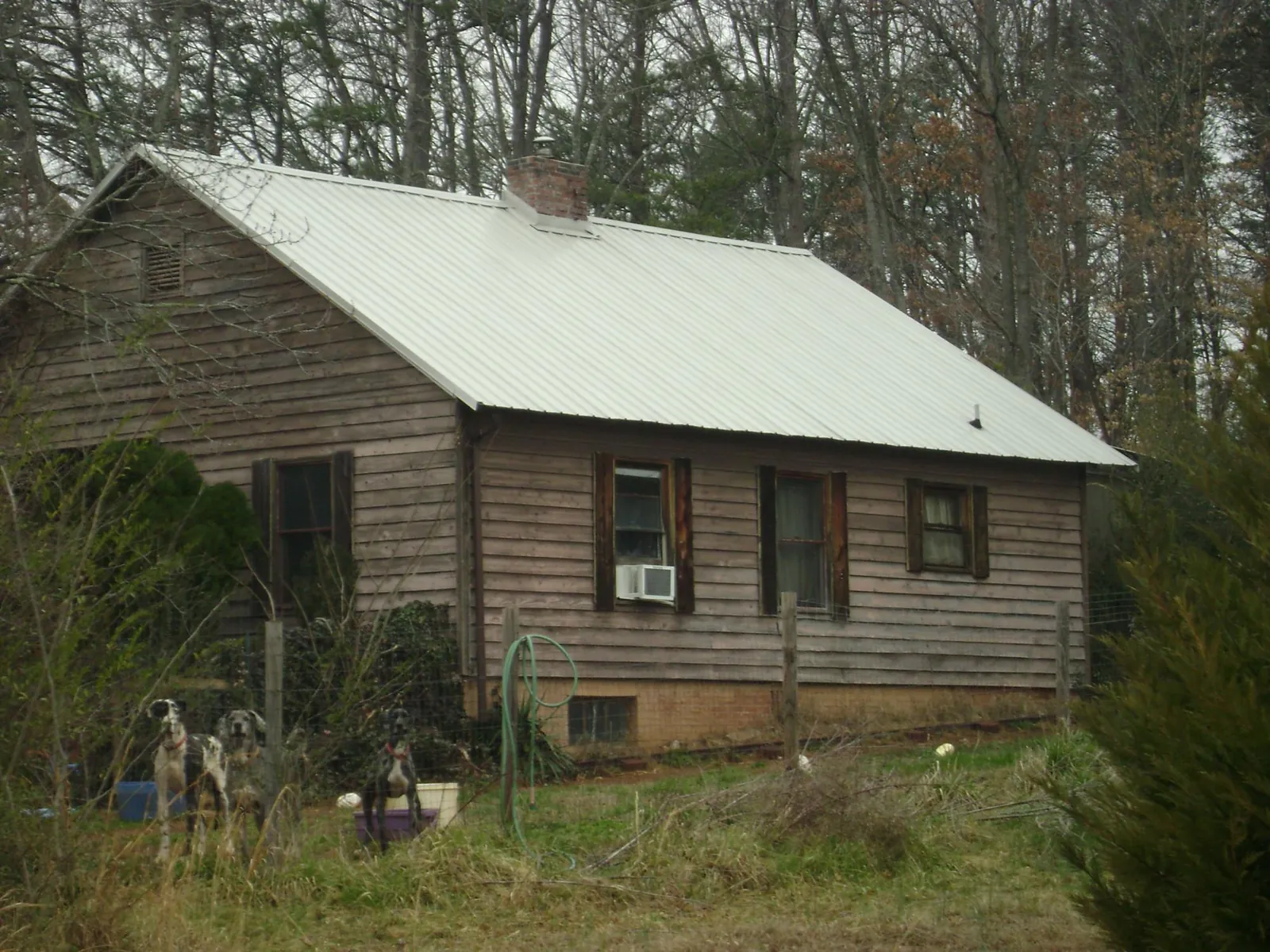 White metal roof on an old wood sided farmhouse, from a Asphalt Shingle Roof Repair job in Lithonia